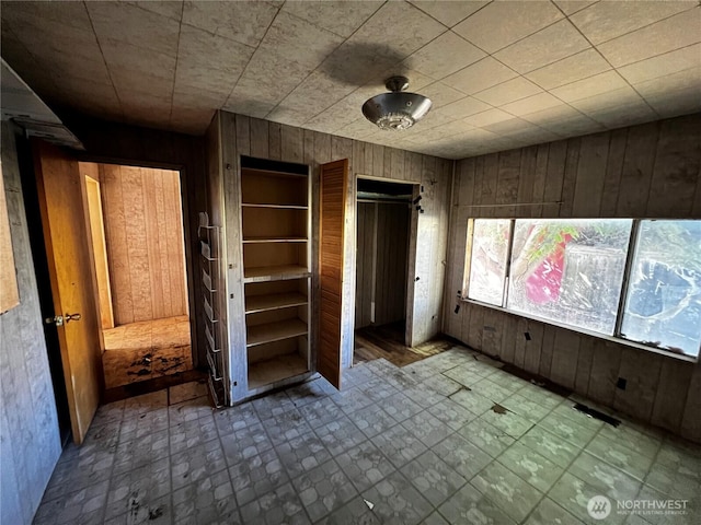 2405 Elmway, Okanogan, WA 98840 - unfurnished bedroom featuring wood walls and multiple closets