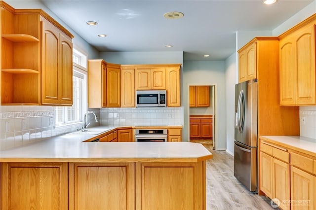2800 Cliff St, Port Townsend, WA 98368 - kitchen with stainless steel appliances, a peninsula, light countertops, light wood finished floors, and recessed lighting