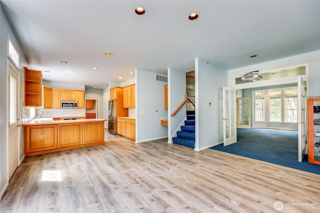 2800 Cliff St, Port Townsend, WA 98368 - kitchen featuring stainless steel appliances, light wood-style flooring, a peninsula, french doors, and recessed lighting