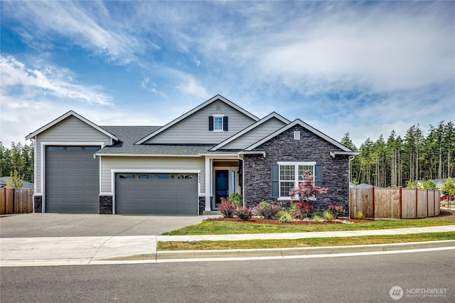 4689 Petrel St, Port Townsend, WA 98368 - view of front facade featuring stone siding, an attached garage, driveway, and a shingled roof