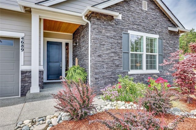 4689 Petrel St, Port Townsend, WA 98368 - view of exterior entry with stone siding and an attached garage