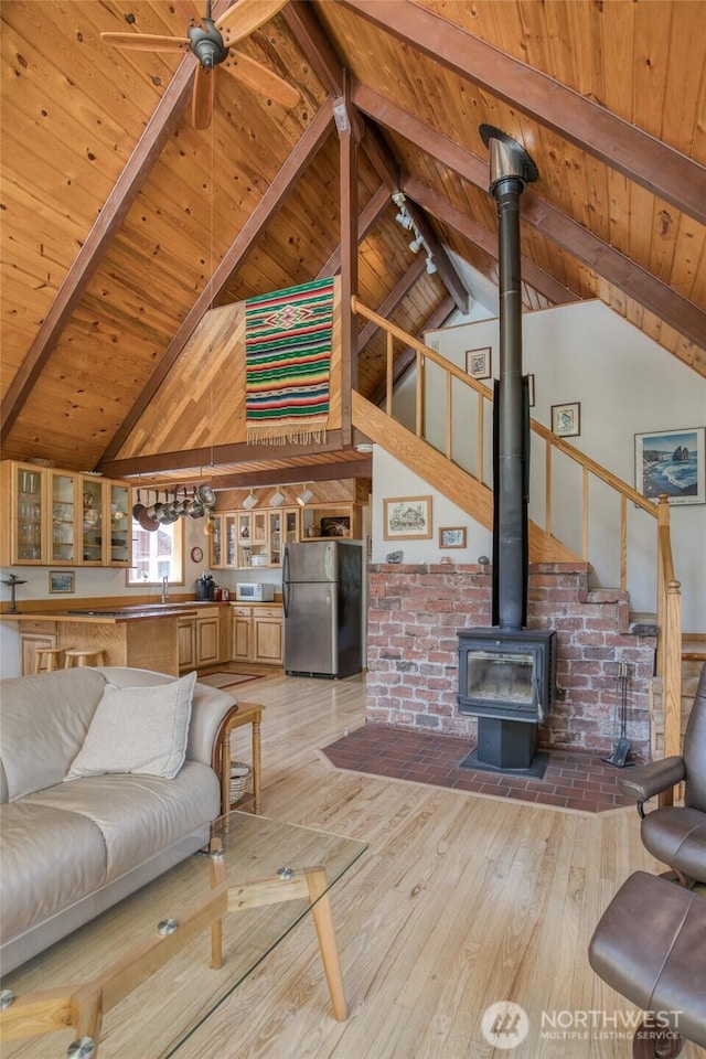 1211 E Market St, Aberdeen, WA 98520 - living room featuring wooden ceiling with exposed beams, light wood-style floors, a wood stove, and high vaulted ceiling