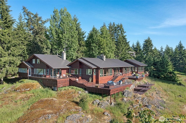 2000 Mount Dallas Rd, Friday Harbor, WA 98250 - back of house with a wooden deck, a chimney, a metal roof, a forest view, and a standing seam roof