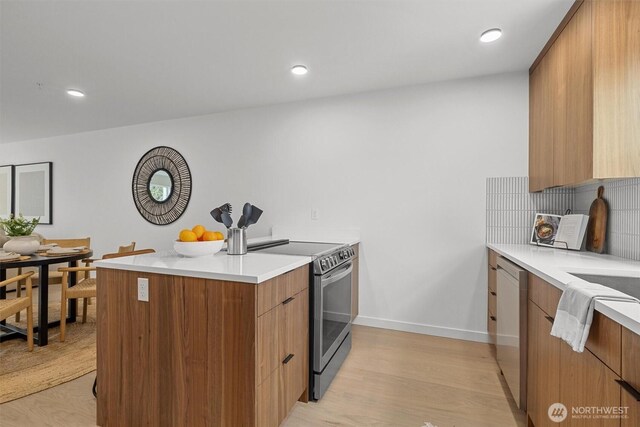 11232 Corliss Ave N, Seattle, WA 98133 - kitchen featuring appliances with stainless steel finishes, modern cabinets, a peninsula, light countertops, and recessed lighting