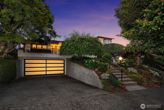 1910 Edgemont Pl W, Seattle, WA 98199 - view of front facade with concrete driveway, a balcony, stairs, and a garage