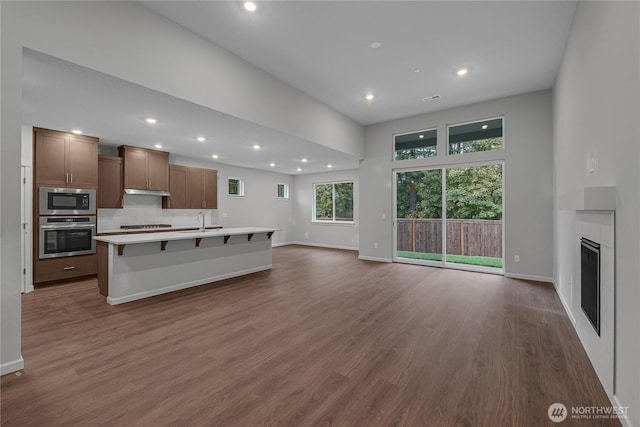2605 S 7th Way, Ridgefield, WA 98642 - unfurnished living room with recessed lighting, a sink, dark wood-style floors, baseboards, and a fireplace