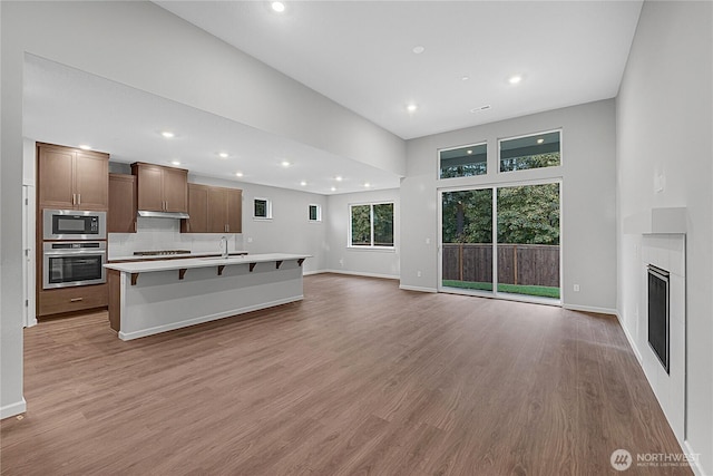2605 S 7th Way, Ridgefield, WA 98642 - unfurnished living room featuring recessed lighting, light wood-type flooring, a sink, baseboards, and a fireplace