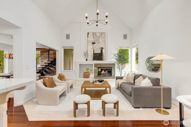 4213 249th Ct SE, Sammamish, WA 98029 - living room featuring wood finished floors, stairway, a chandelier, high vaulted ceiling, and a glass covered fireplace