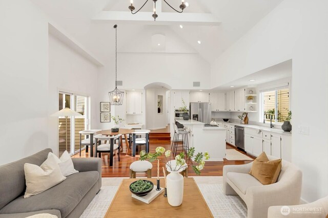 4213 249th Ct SE, Sammamish, WA 98029 - living area featuring a chandelier, wood finished floors, high vaulted ceiling, beam ceiling, and arched walkways