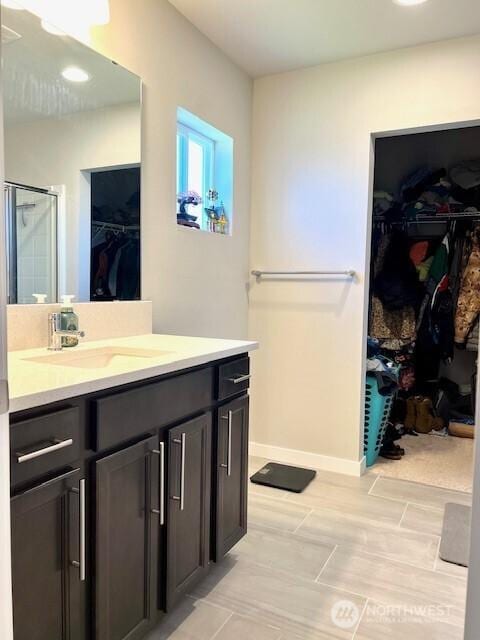 1342 Cascade St, Sultan, WA 98294 - bathroom featuring a walk in closet, vanity, a stall shower, and baseboards