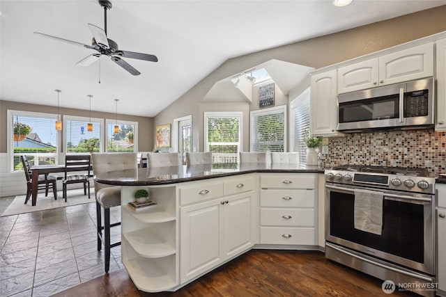 1910 Lenox Ct NW, Olympia, WA 98502 - kitchen featuring stainless steel appliances, open shelves, a peninsula, healthy amount of natural light, and vaulted ceiling