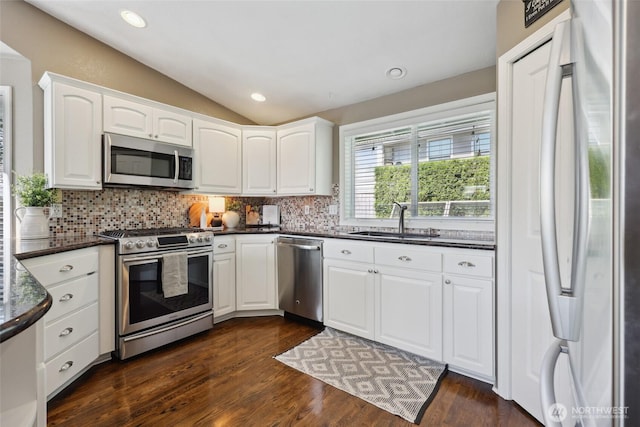 1910 Lenox Ct NW, Olympia, WA 98502 - kitchen with stainless steel appliances, dark countertops, lofted ceiling, backsplash, and white cabinetry