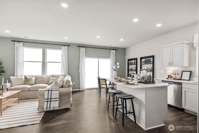 1725 Noble Ave Unit 81, Snohomish, WA 98290 - kitchen with stainless steel dishwasher, a kitchen bar, light countertops, dark wood finished floors, and a kitchen island with sink