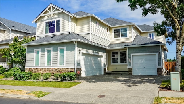 21502 51st Ave S Unit 44, Kent, WA 98032 - view of front of house featuring stone siding, driveway, roof with shingles, an attached garage, and a garage