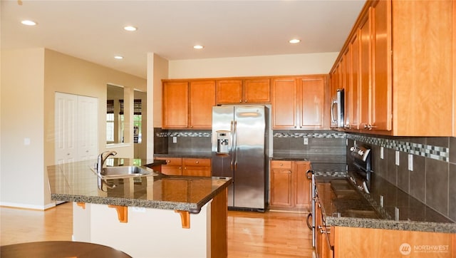 21502 51st Ave S Unit 44, Kent, WA 98032 - kitchen featuring stainless steel appliances, light wood-style floors, brown cabinetry, decorative backsplash, and recessed lighting