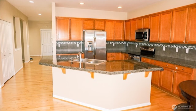 21502 51st Ave S Unit 44, Kent, WA 98032 - kitchen featuring stainless steel appliances, brown cabinetry, tasteful backsplash, light wood-style flooring, and recessed lighting