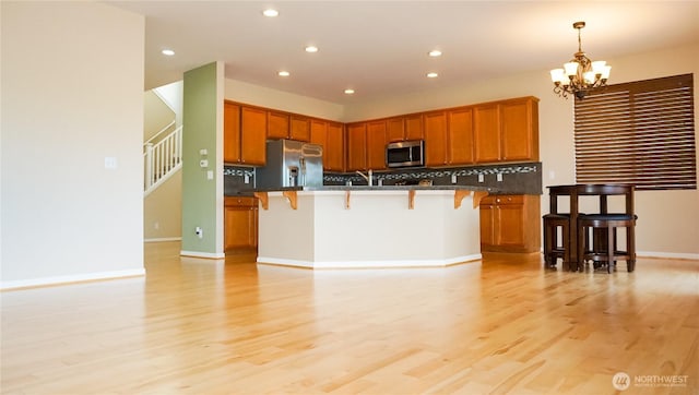 21502 51st Ave S Unit 44, Kent, WA 98032 - kitchen with appliances with stainless steel finishes, a breakfast bar area, dark countertops, a chandelier, and recessed lighting