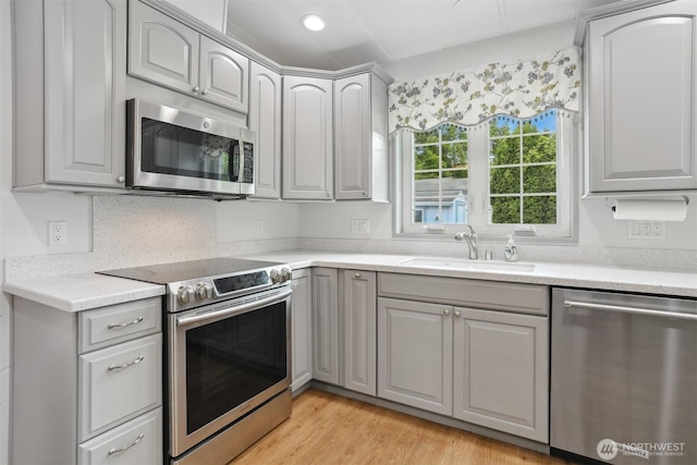 23704 9th Pl W, Bothell, WA 98021 - kitchen with appliances with stainless steel finishes, gray cabinetry, light wood-style flooring, and light countertops