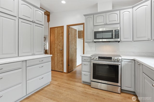 23704 9th Pl W, Bothell, WA 98021 - kitchen featuring appliances with stainless steel finishes, gray cabinets, light countertops, light wood-type flooring, and recessed lighting