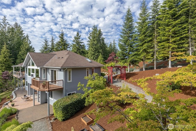 63 Red Cedar Ln, Port Ludlow, WA 98365 - rear view of property featuring a patio, a wooden deck, and a shingled roof