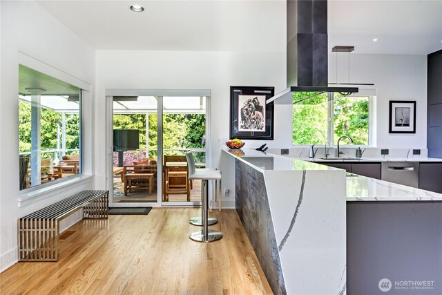 63 Red Cedar Ln, Port Ludlow, WA 98365 - kitchen with modern cabinets, light stone countertops, light wood-style floors, exhaust hood, and a peninsula