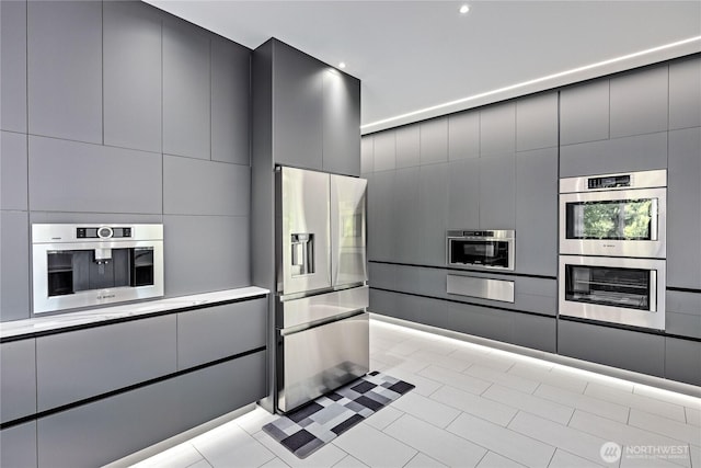 63 Red Cedar Ln, Port Ludlow, WA 98365 - kitchen featuring appliances with stainless steel finishes, a warming drawer, gray cabinetry, modern cabinets, and light tile patterned floors