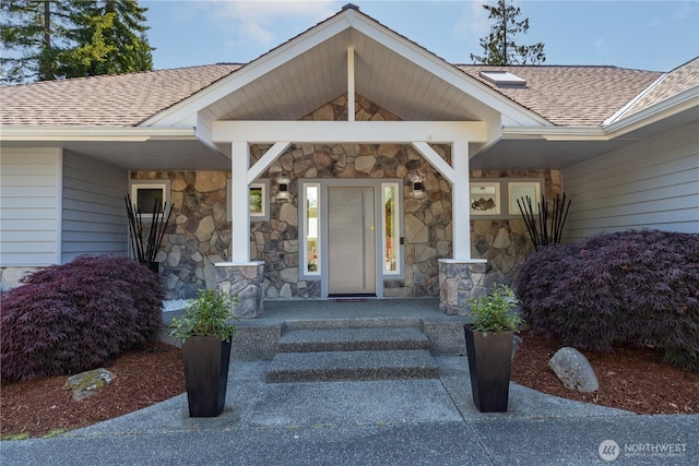 63 Red Cedar Ln, Port Ludlow, WA 98365 - doorway to property with roof with shingles, stone siding, and a porch