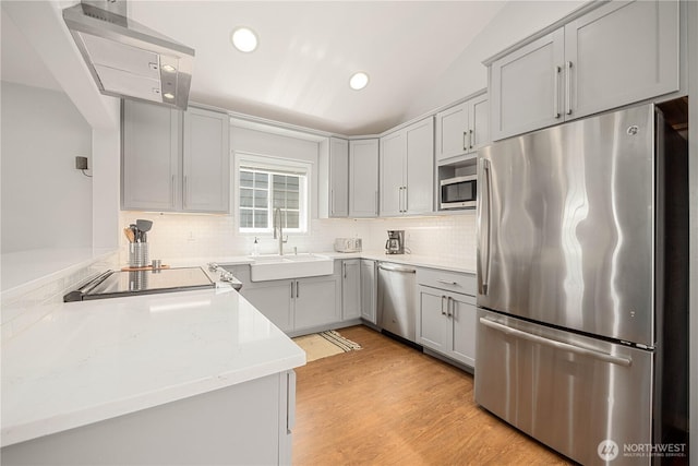 244 N Emerson Ave, Wenatchee, WA 98801 - kitchen with appliances with stainless steel finishes, gray cabinetry, decorative backsplash, light wood-type flooring, and ventilation hood