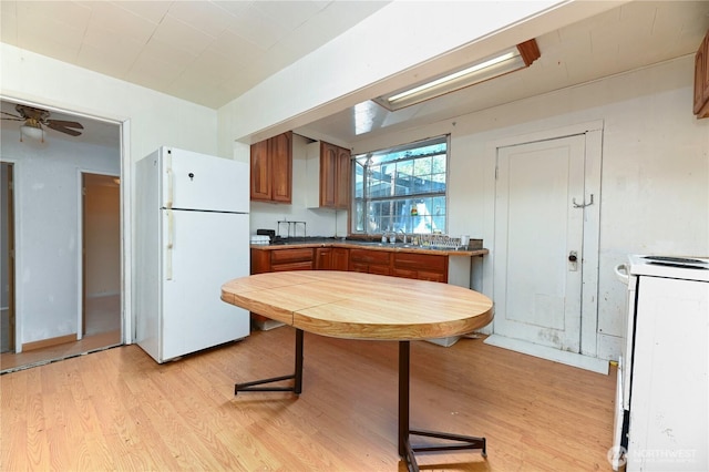 7029 Riverview Rd, Snohomish, WA 98290 - kitchen with white appliances, brown cabinetry, light wood-style flooring, and a sink
