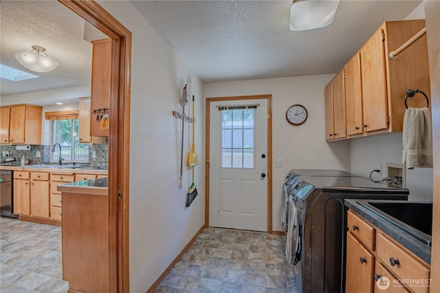 180N Mount Christie Dr, Hoodsport, WA 98548 - laundry room featuring washer and dryer, baseboards, a textured ceiling, cabinet space, and a skylight