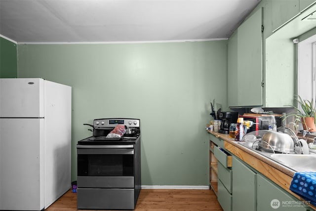 101 N Elm St N, Omak, WA 98841 - kitchen featuring freestanding refrigerator, stainless steel range with electric cooktop, green cabinets, light wood-style floors, and a sink