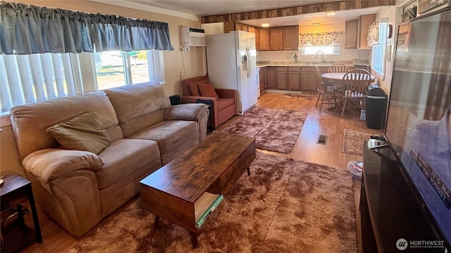 545 Hendricks St Unit 33, Port Townsend, WA 98368 - living room featuring light wood-type flooring, plenty of natural light, and an AC wall unit