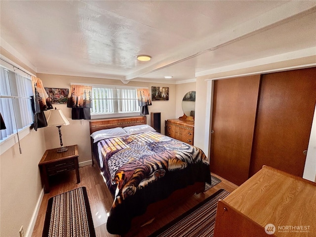 545 Hendricks St Unit 33, Port Townsend, WA 98368 - bedroom with wood finished floors, beam ceiling, and a closet