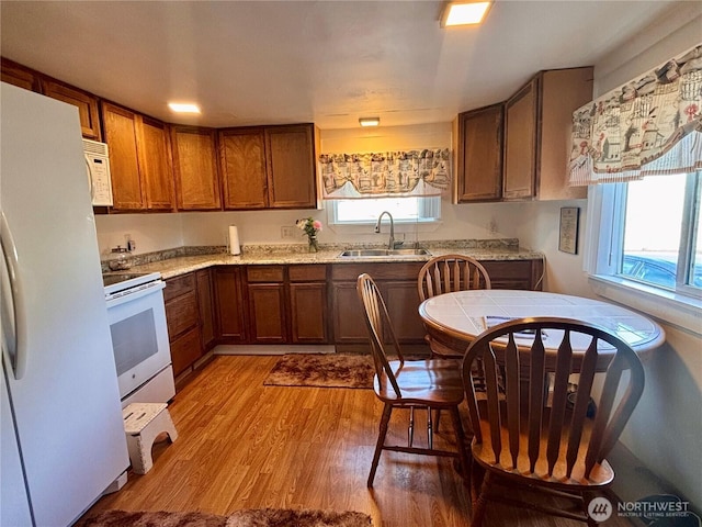 545 Hendricks St Unit 33, Port Townsend, WA 98368 - kitchen featuring white appliances, light wood-style floors, brown cabinetry, and light countertops