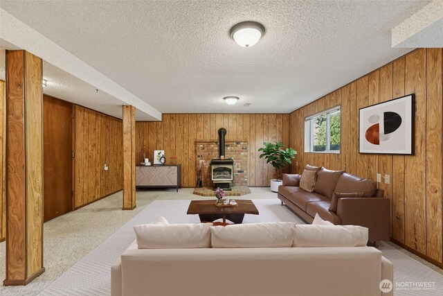 1001 Garden Dr, Lynden, WA 98264 - living area with wooden walls, a wood stove, a textured ceiling, and light colored carpet