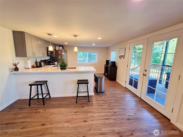 255 S Union Rd, Elma, WA 98541 - kitchen with appliances with stainless steel finishes, a peninsula, a breakfast bar area, light countertops, and light wood-style floors