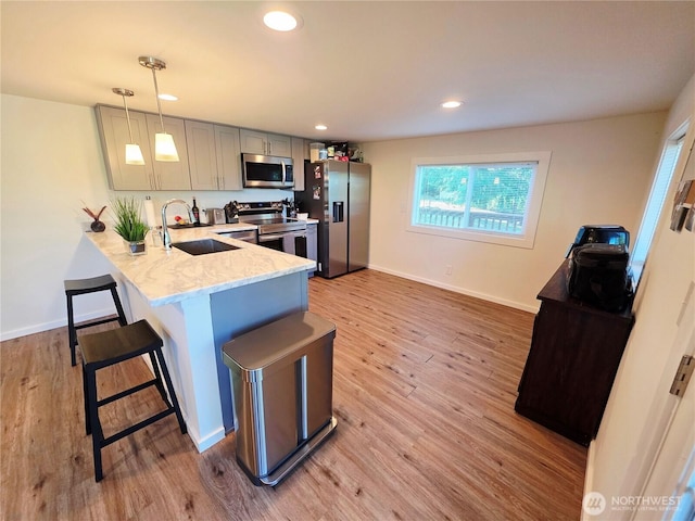 255 S Union Rd, Elma, WA 98541 - kitchen with appliances with stainless steel finishes, a sink, a breakfast bar, light wood-style floors, and a peninsula