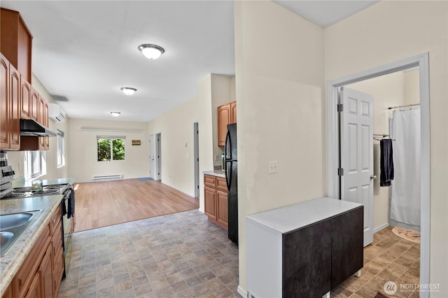 2415 Cedar St, Everett, WA 98201 - kitchen featuring freestanding refrigerator, under cabinet range hood, range with electric cooktop, a wall mounted AC, and light countertops