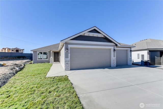 4246 W Sandy Ct, Moses Lake, WA 98837 - single story home with a garage, stone siding, driveway, and a front lawn
