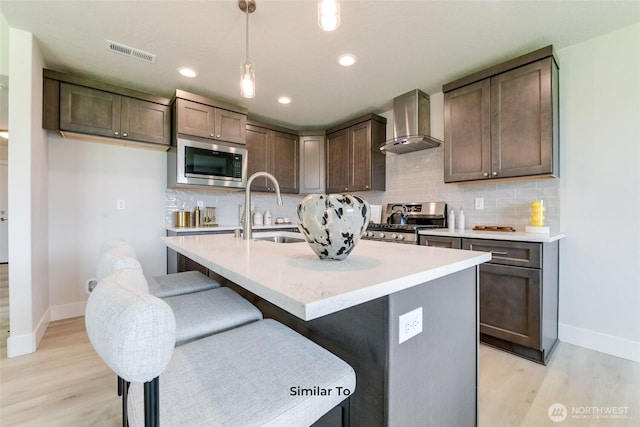 4246 W Sandy Ct, Moses Lake, WA 98837 - kitchen featuring wall chimney range hood, appliances with stainless steel finishes, light wood-type flooring, hanging light fixtures, and recessed lighting
