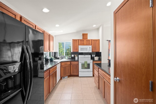 134 Wind River Dr, Chehalis, WA 98532 - kitchen with white appliances, vaulted ceiling, dark countertops, a sink, and light tile patterned floors