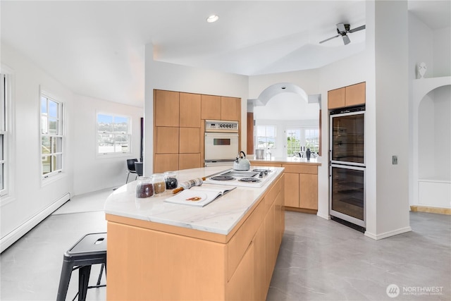 2053 Minor Ave E Unit 12, Seattle, WA 98102 - kitchen featuring modern cabinets, white appliances, a kitchen island, arched walkways, and a baseboard heating unit