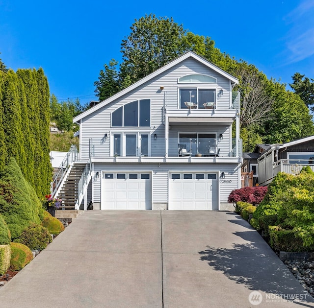 28440 Sound View Dr S, Des Moines, WA 98198 - view of front of house with an attached garage, concrete driveway, stairs, and a balcony