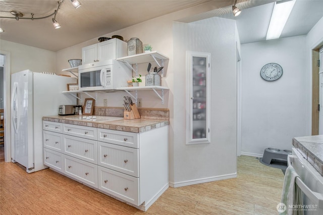2685 E Hoquiam Rd, Hoquiam, WA 98550 - kitchen featuring open shelves, white appliances, light countertops, white cabinetry, and light wood-type flooring
