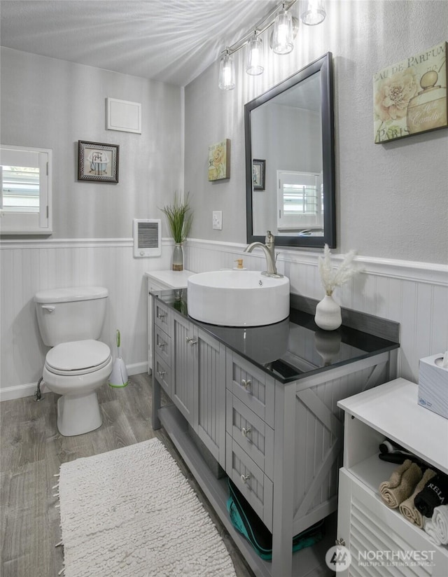 2685 E Hoquiam Rd, Hoquiam, WA 98550 - bathroom with a wainscoted wall, vanity, toilet, wood finished floors, and heating unit