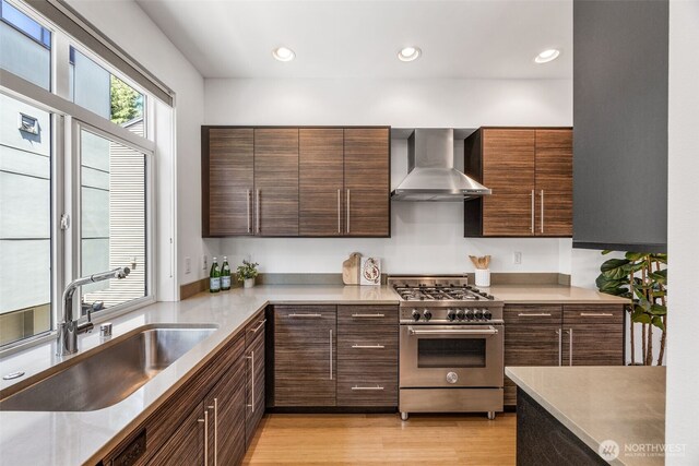 203 20th Ave E, Seattle, WA 98112 - kitchen featuring stainless steel range, wall chimney range hood, a sink, modern cabinets, and light countertops