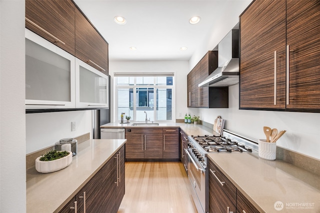 203 20th Ave E, Seattle, WA 98112 - kitchen featuring stainless steel appliances, modern cabinets, a sink, wall chimney range hood, and light countertops