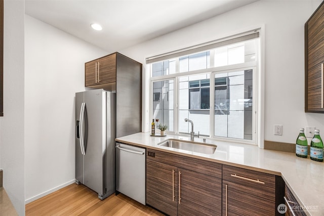 203 20th Ave E, Seattle, WA 98112 - kitchen featuring stainless steel appliances, a sink, light wood finished floors, light countertops, and recessed lighting