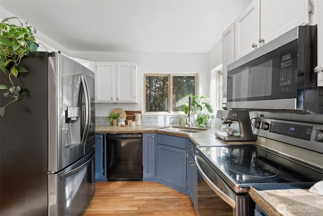 415 Sudden Valley Dr, Bellingham, WA 98229 - kitchen with stainless steel appliances, blue cabinets, a sink, white cabinets, and light wood finished floors