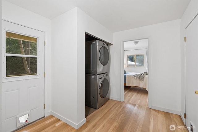 415 Sudden Valley Dr, Bellingham, WA 98229 - laundry room featuring stacked washer / dryer, light wood finished floors, healthy amount of natural light, and baseboards